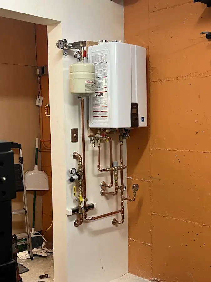 Plumbing technician inspecting water heater connections in Poteet